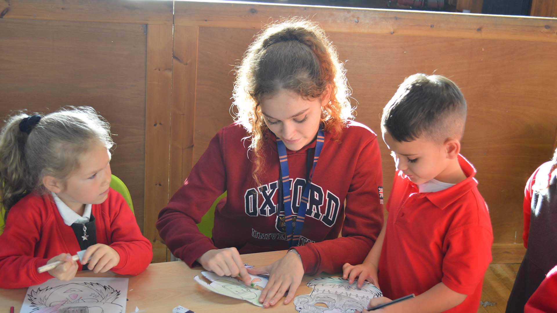 An team member from St. Peter's Out of School Clun in Cardiff takes part in a fun activity with children in the club's care.